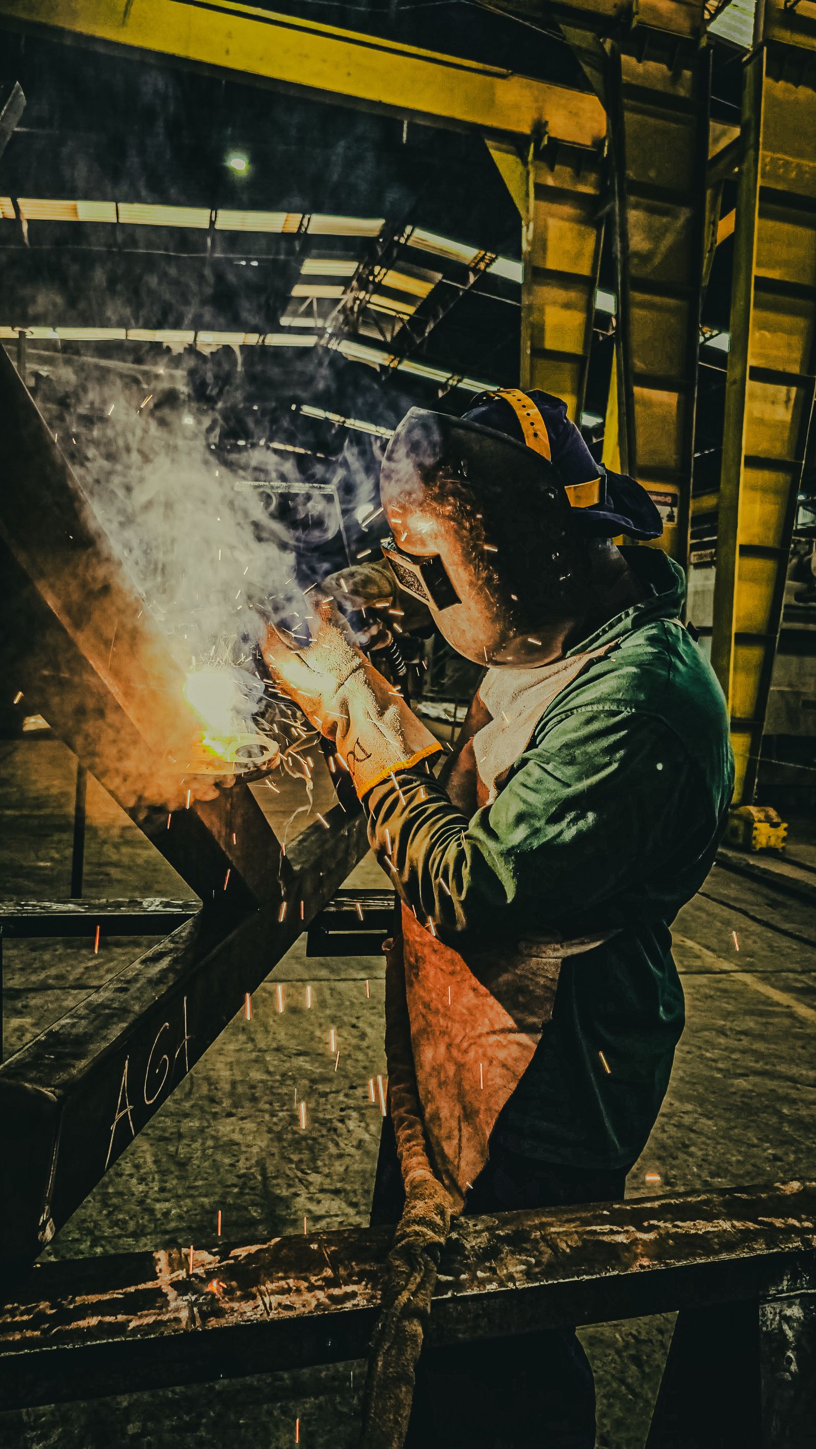 Certified welder joining heavy steel with sparks flying